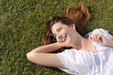 Naklejka na ściany i meble Happy relaxed woman lying on the grass