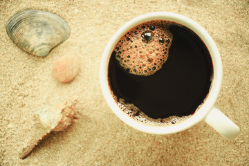 Cup of coffee put in sand at the beach, Relax concept.