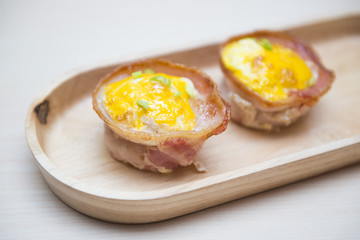 baked egg in bacon bowl on wooden tray