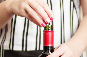Female unscrews the screw cap wine bottle