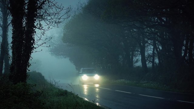 Car Drives Through Misty Countryside In The Rain