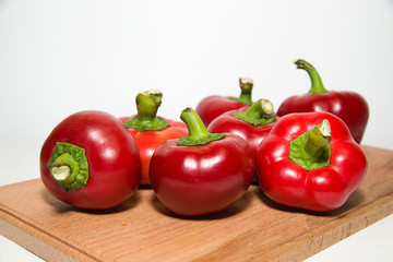 Many ripe red peppers on over white