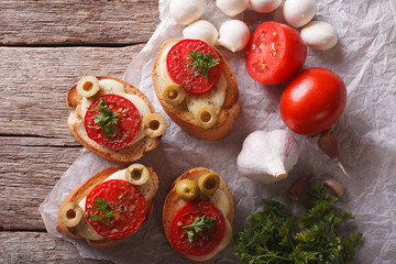 crostini with tomatoes, olives and cheese closeup. horizontal top view
