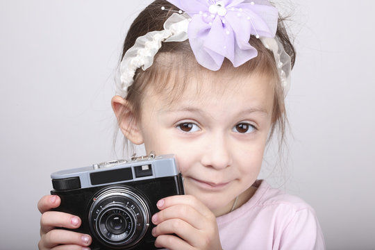 Young girl holding an old vintage camera 