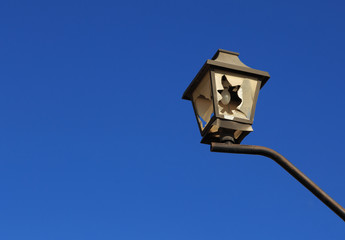 Broken city light on the blue sky background.