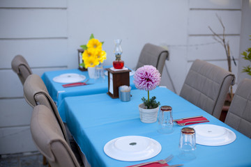 Mesa con mantel azul y flores amarillas y violetas