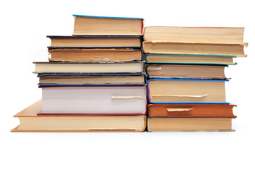 A stack of old books with bookmarks in different directions on d