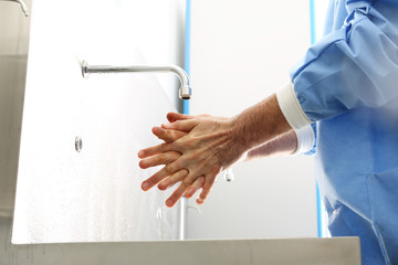 Fototapeta Chirurgiczna dezynfekcja rąk. Lekarz myje ręce, dezynfekuje ręce przed rozpoczęciem operacji obraz