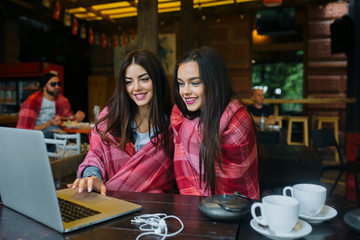 two girls watching something in laptop