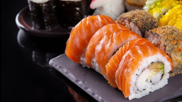 Slide motion of sushi food served on black stone