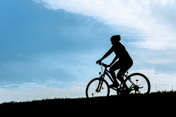 Silhouette of the cyclist riding a mountain bike.