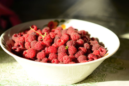 ripe raspberries on a plate light