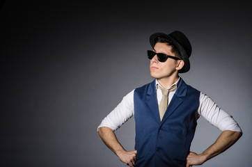 Obraz premium Young man in blue vest and hat against gray