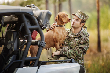 Hunter with Rifle and Four Wheeler Tire in forest