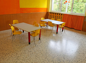 kindergarten classroom with desks and yellow chairs