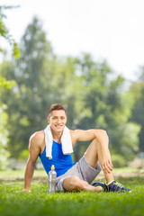 Vertical shot of a young athlete sitting in a park