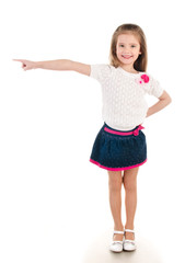 Smiling little girl points direction by forefinger