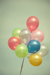 Fototapeta na wymiar multicolored balloons on blue sky ; vintage color tone.
