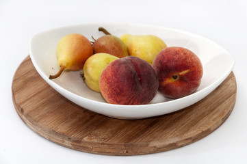 Fresh pears and peaches in a bowl