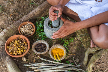 A young man preparing ayurvedic medicine in the traditional manner in India
 - obrazy, fototapety, plakaty