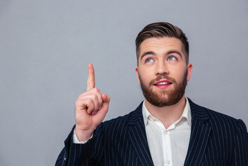 Thoughtful businessman pointing finger up
