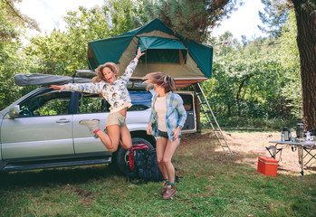 Young women having fun in campsite with 4x4 on background © David Pereiras