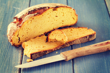 corn bread with knife on blue wooden background