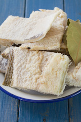 salted cod fish on dish on blue wooden background
