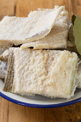 salted cod on dish on brown wooden background