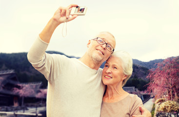 senior couple with camera over asian village