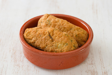 cod fish croquettes on dish on white background