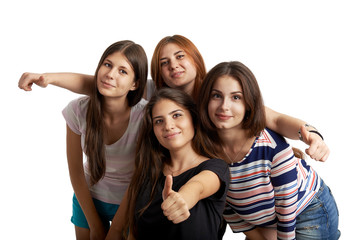 Studio portrait of pretty teenage girls embracing, showing thumbs up over white background. Concept of team, success and confidence. 