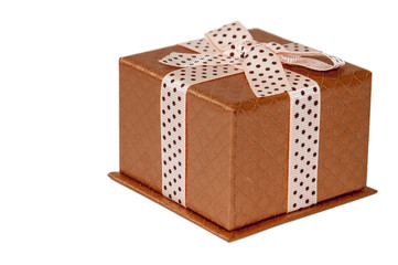 Closed golden gift box with bow over white