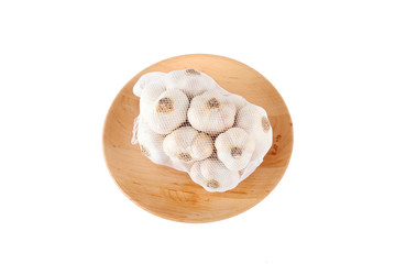 Garlic on wooden plate isolated on white