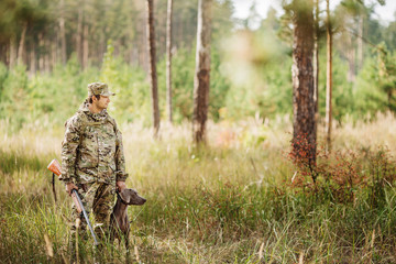 yang Hunter avec fusil et chien en forêt