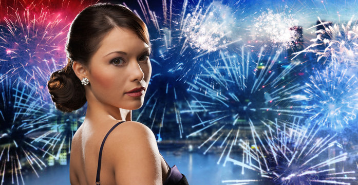 beautiful woman with diamond earring over firework