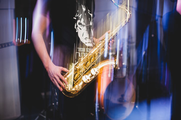  man plays the saxophone close up. freezelight