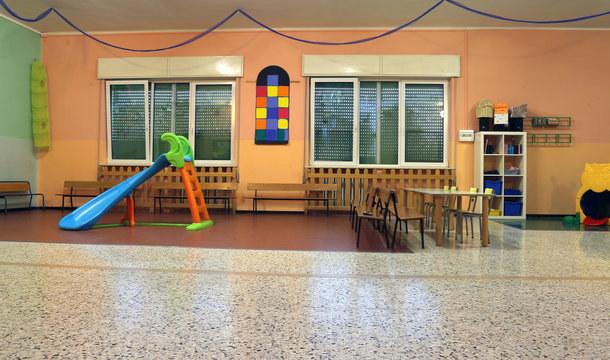 plastic slide for kids and desks with little chairs in the kinde