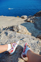 Overhead photo of feet on a background of seaview. Women feets