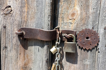 Vintage door lock with chains and padlock on wooden door