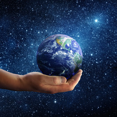 Planet earth on palm and space background. Conceptual Image. Elements of this image furnished by NASA