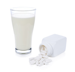 glass of milk and Medical pill tablet isolated on white backgrou