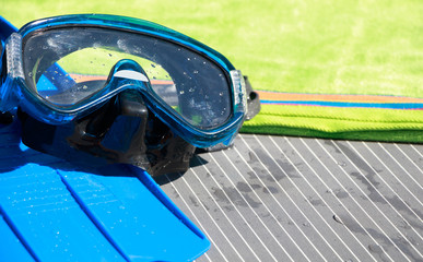 Wet mask and scuba fins on a towel