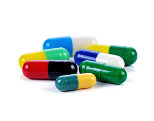 Colored pills, tablets and capsules on a white background