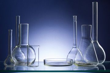 Assorted empty laboratory glassware, test-tubes. Blue tone medical background. Copy space