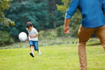 Summer football. Dad and son playing soccer.