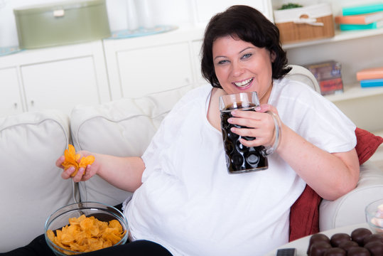 übergewichtige frau mit cola und chips