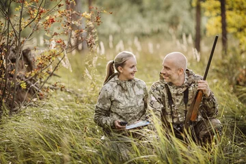 Crédence de cuisine en verre imprimé Chasser Chasseurs avec fusil et pneu à quatre roues en forêt