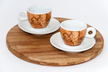 Pair of beautiful coffee mugs on the wooden board