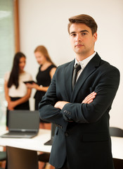 Young Business man   standing in first plain with coworkers in b
